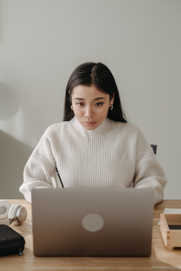 Woman in White Turtleneck Sweater Using Silver Macbook